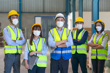 Group of Asian male and female engineers team wearing hygienic mask protect with helmet safety...