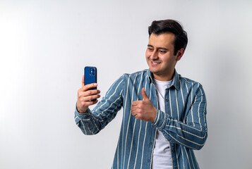 Close up photo of a brown skinned young adult model, making video call with smartphone on isolated white background.
