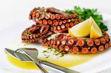 Delicious octopus salad with dressing, lemon and parsley on white background. Healthy eating....