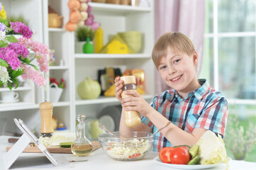 Portrait of cute little boy making dinner
