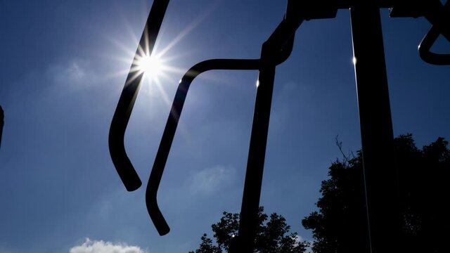 Power push facility in the park. Fitness equipment for middle-aged and elderly people. Close up on handlebars. Backlight shot.