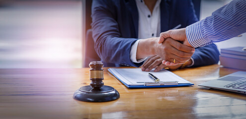 Close up of Businessman shaking hands to seal a deal with his partner lawyers or attorneys discussing a contract agreement.
