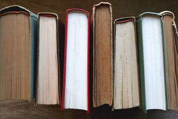 Bunch of vintage hardcover books on wooden background. Top view.