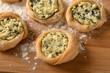 open sfiha filled with ricotta cheese and spinach on a wood