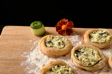open sfiha filled with ricotta cheese and spinach on a wood