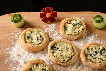 open sfiha filled with ricotta cheese and spinach on a wood