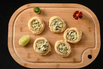 open sfiha filled with ricotta cheese and spinach on a wood