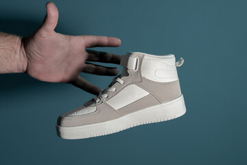 Stealing shoes. The hand reaches for the sneaker. Blue background