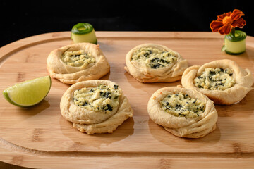 open sfiha filled with ricotta cheese and spinach on a wood