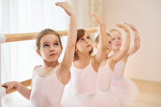 Fototapeta Little ballerinas preparing for performance by practicing dance moves