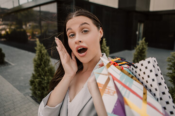 Shocked lady hold hands many bags shopper woman dressed plaid blazer carrying enjoying new clothes packs things after shopping buyings sales black friday concept