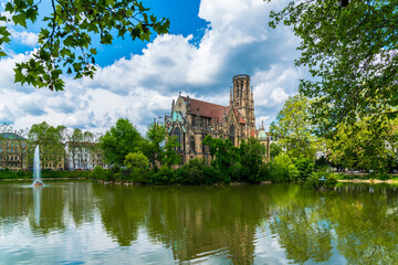 Obraz premium Germany, Stuttgart city downtown feuersee urban park st john church reflecting in lake water between green trees