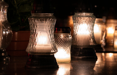 Cemetery grave candle lanterns, illuminated by night. All Saints' Day, Feast of All Souls....