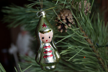 Vintage old glass Christmas tree toy 1970s Soviet period dolls - a red army boy on pine branches close-up.