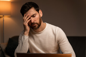 Stressed overworked businessman freelancer exhausted after hard work, suffering from migraine