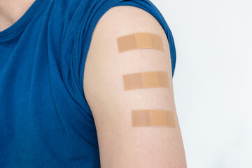 close up of multiple bandages plasters on upper arm