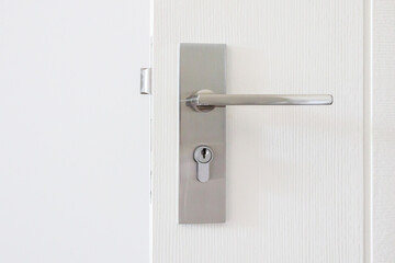 Modern door handle with keyhole on white door