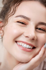 Obraz premium Closeup face Young pretty woman with curly hair smiles and looks into frame in robe, concept of cosmetology beauty salon