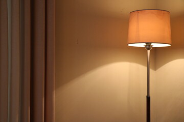 Floor Lamp with yellow light beside Curtain in the living room