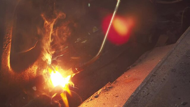 cutting metal with a gas burner. a man cuts metal. cutting with propane and oxygen. working with metal structures. sparks from the fire