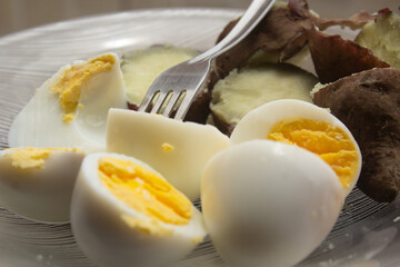 Partial view of a plate with boiled egg and sweet potato