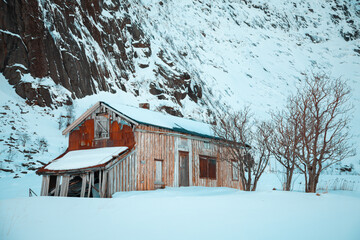 Old abandoned barn between snowy mountains in the arctic circle