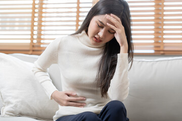 Flatulence asian young woman, girl hand in stomach ache, suffer from food poisoning, abdominal pain...
