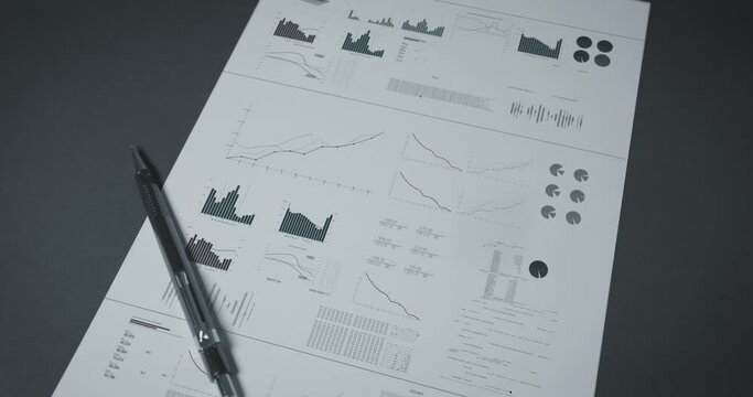 Digitally animated graph chart worksheet business analyst development data on a white paper with pen