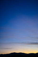 Vertical silhouette of mountain range with sky in blue hour