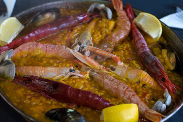 Paella de mariscos. Arroz cocinado en la paellera, recipiente de hierro de poco fondo con dos asas,. Paella Valencia uno de los platos más tradicional