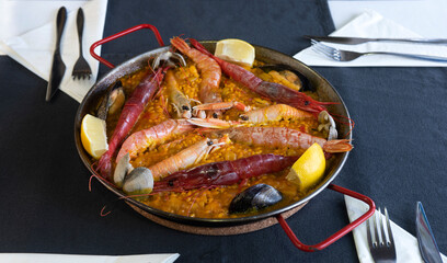 Paella de mariscos. Arroz cocinado en la paellera,  recipiente de hierro de poco fondo con dos asas,. Paella Valencia uno de los platos más tradicional
