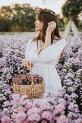 Thai woman with basket with flowers in flower field