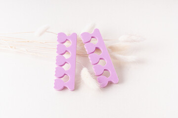 Purple toe dividers and lagurus. Tool for pedicure. Beauty groom hygiene elements