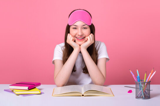 Cheerful Smiling School Girl Sit Desk Reading Book Glad To Finish Homework, Happy About Holidays Are Coming Soon, Going To Sleep Wearing Pink Sleep Mask Distance Online Education Quarantine Concept