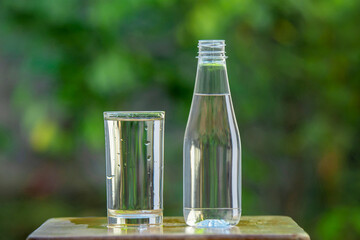 A pair of clean water bottles and glasses rested on a wooden stick.