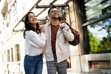 Husband and wife outdoors. Girlfriend and boyfriend walking in the city. Couple enjoy in sunny day.