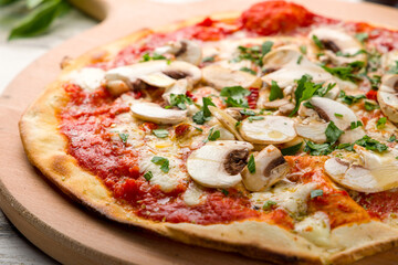 pizza with mushrooms, cheese and tomato sauce on the board macro close up