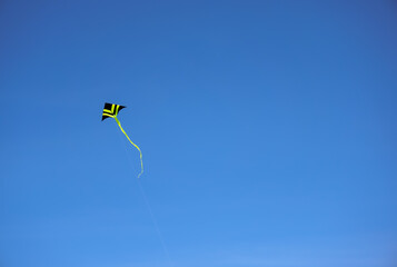 kite flying in clear blue sky. Outdoor leisure activity to free your mind.  Copy space.