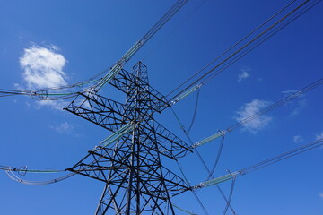 high voltage electricity pylons under blue sky. Energy and power concept. Power lines and tower. 