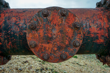Close up of industrial flow pipe. Gas or oil pipeline for supply across river. rusty steel pipework
