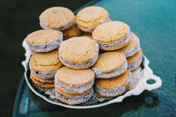 Plate full of cornstarch alfajores filled with dulce de leche.