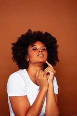 pretty young african american woman with curly hair posing cheerful gesturing on brown background, lifestyle people concept