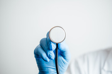 Medical doctor holding a stethoscope head during examination