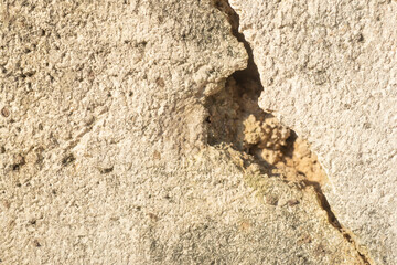The concrete wall surface has cracks and damage.