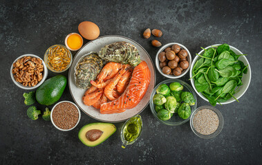 Fototapeta na wymiar Omega 3 foods composition on dark concrete background. Ketogenic and paleo diets concept. Top view