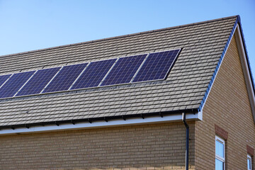 Fototapeta premium solar panels on roof of new build house. Sustainable and clean energy source. Solar energy and environment concept