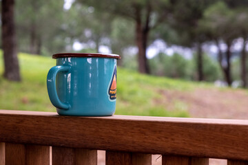 blue mug in wooden gazebo with forest landscape, selective focus