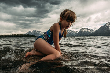 Young girl swimming in mountain lake