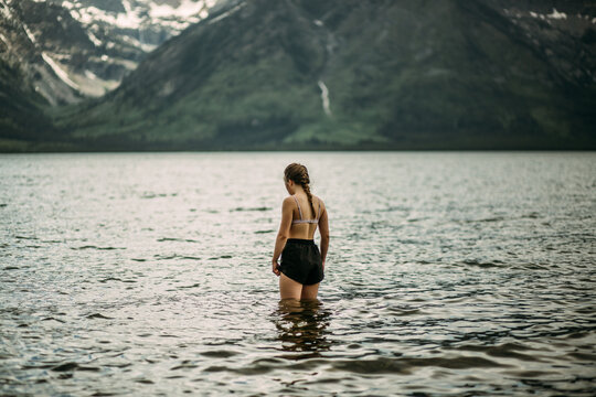 Teen girl swimming in alpine lake