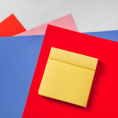 Yellow sticky notes on colored paper. Sticker on red paper. Business concept. Copy space.